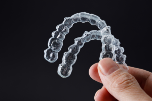 A person holding a clear plastic aligners