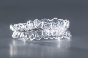 A clear dental braces on a grey surface