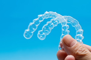 A hand holding a clear dental aligners