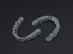 a clear dental aligners on a black surface
