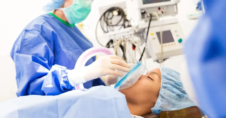Sedation Dentistry in Naples - Medical professional in protective attire administering sedation to a patient in a clinical setting, highlighting a safe and comfortable sedation dentistry experience.