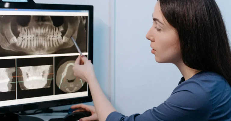 Dentist reviewing dental X-ray for implant planning at Naples Dental Boutique
