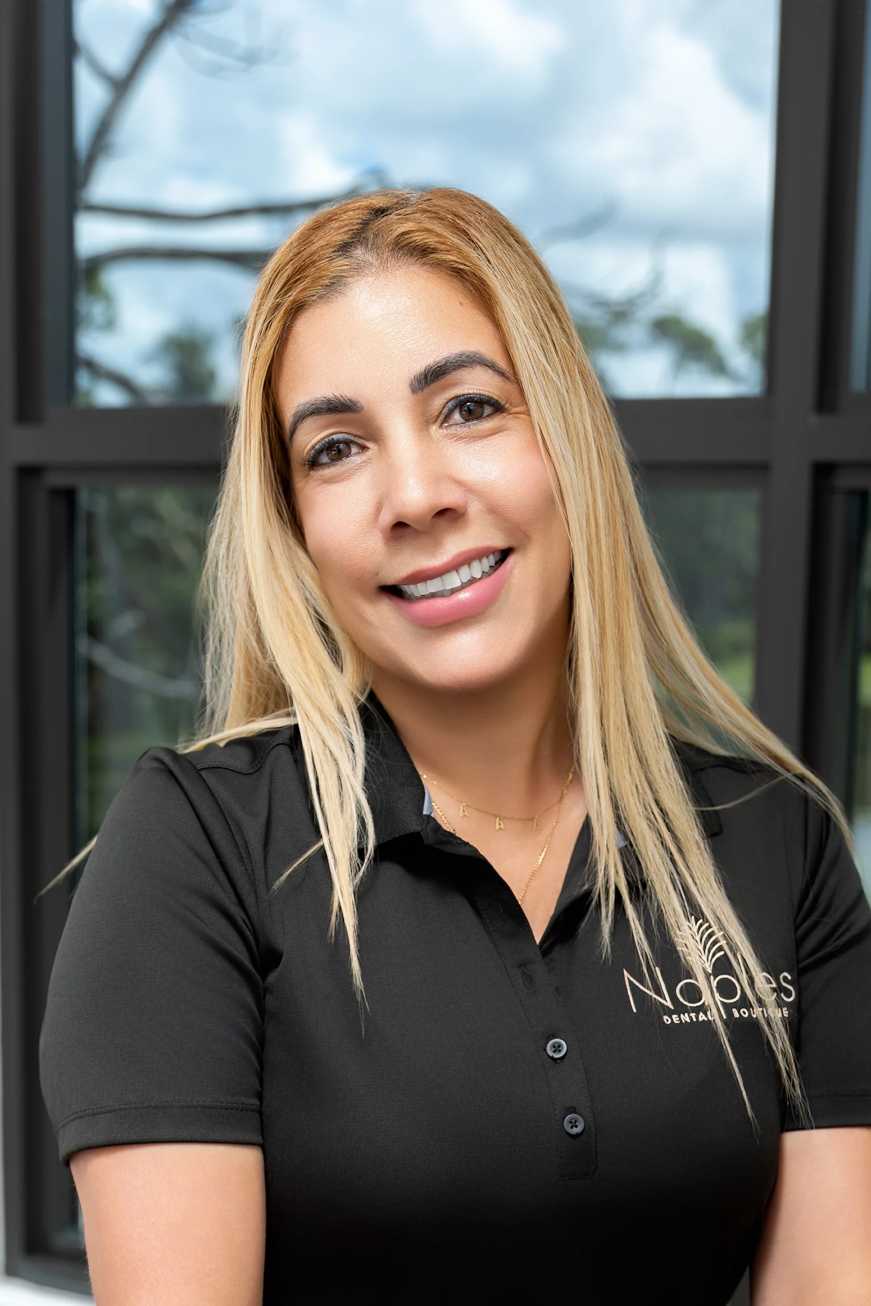 Team member smiling at naples dental boutique reception area
